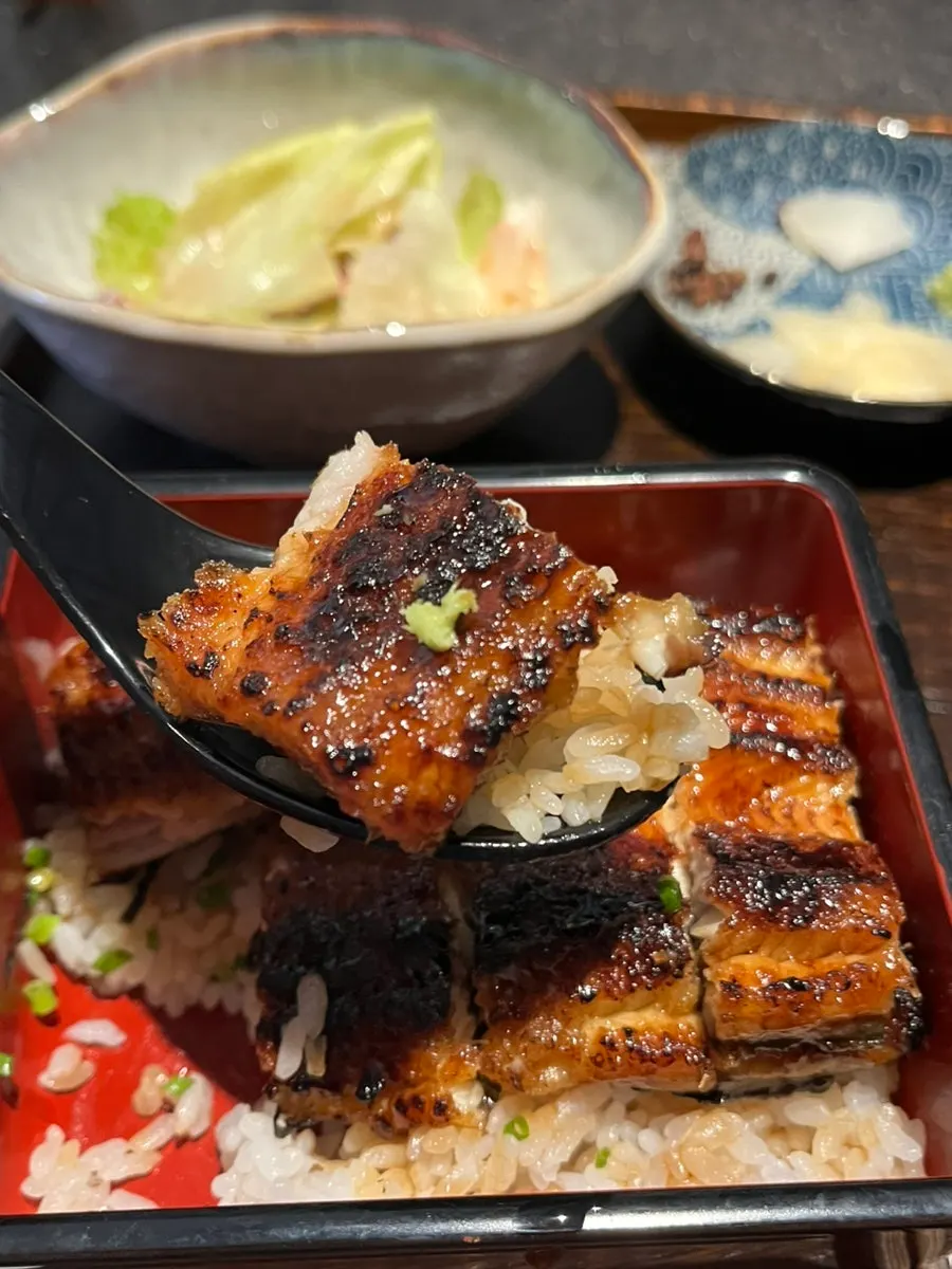 Bocado con anguila y wasabi sobre el arroz