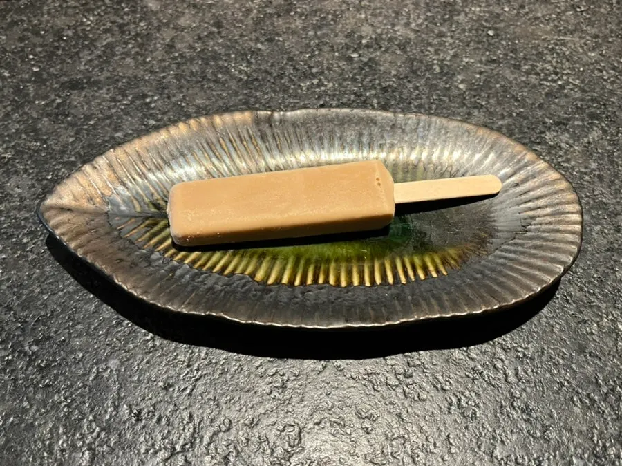 Helado de sabor té negro servido de postre en un platito