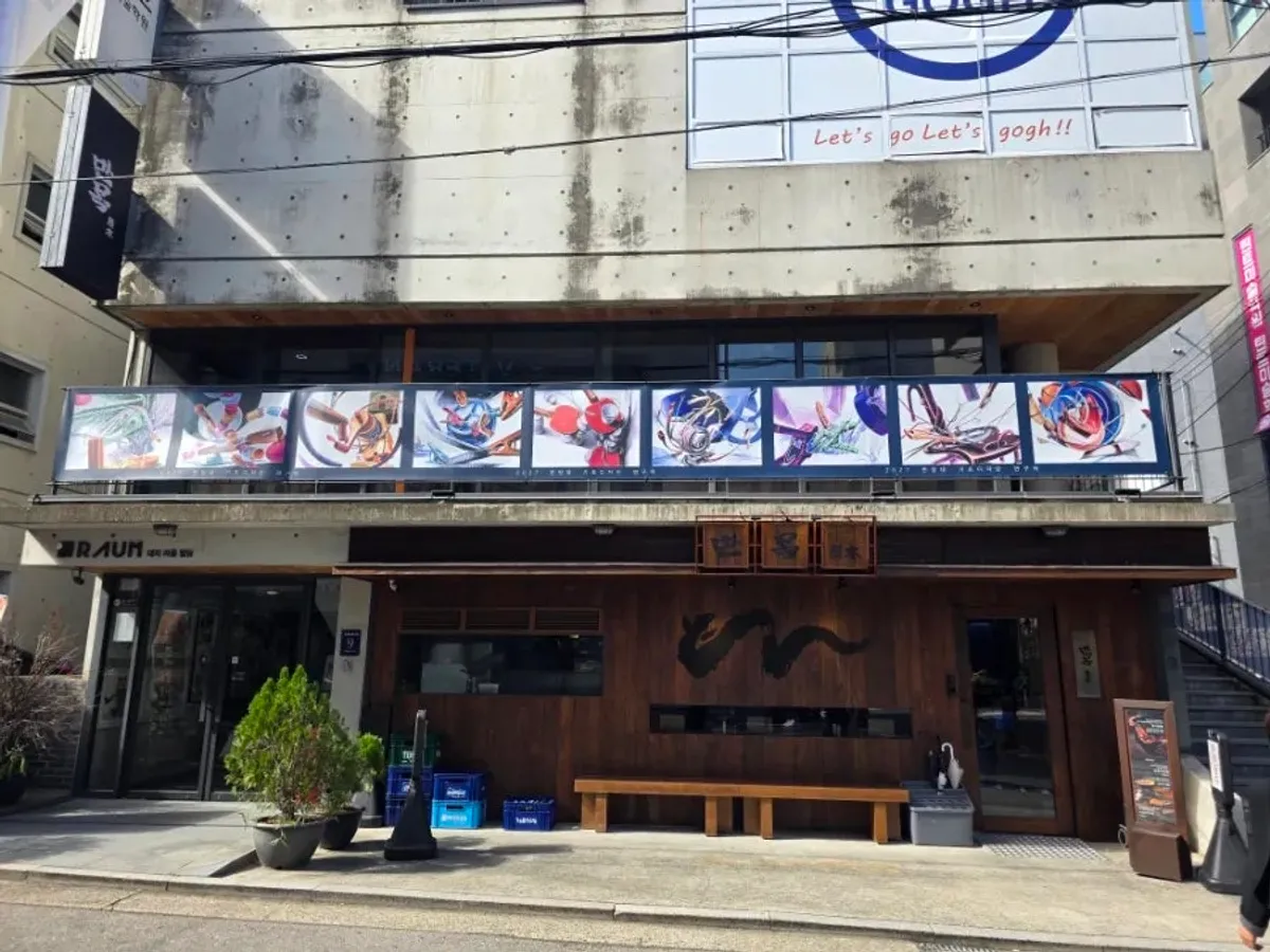 Exterior of Manmok Seonleung with dark wood and a calligraphy sign