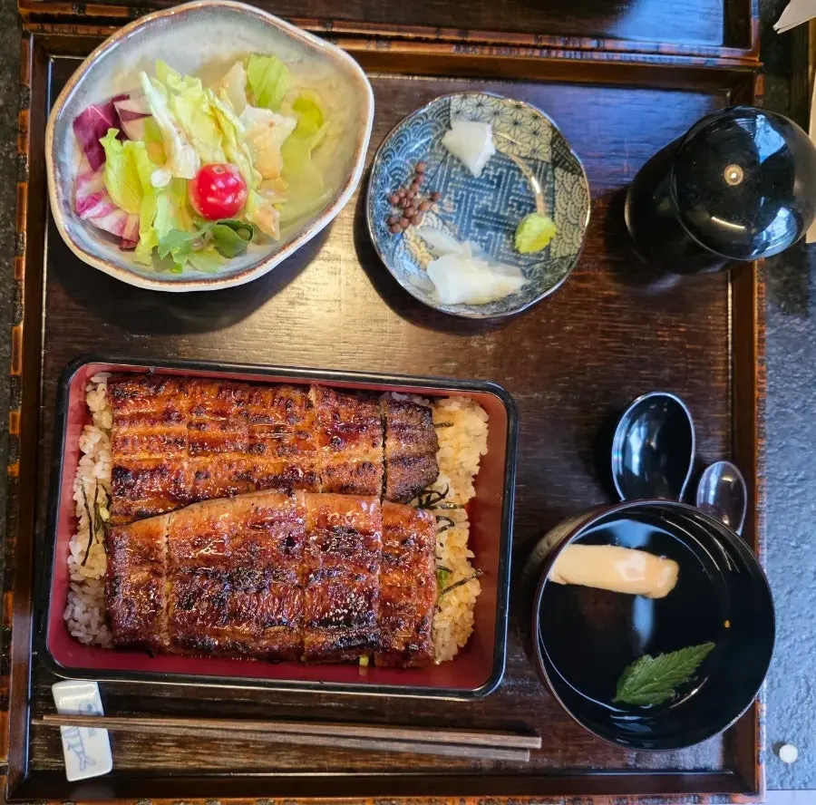 Lid opened to reveal a whole eel covering the rice
