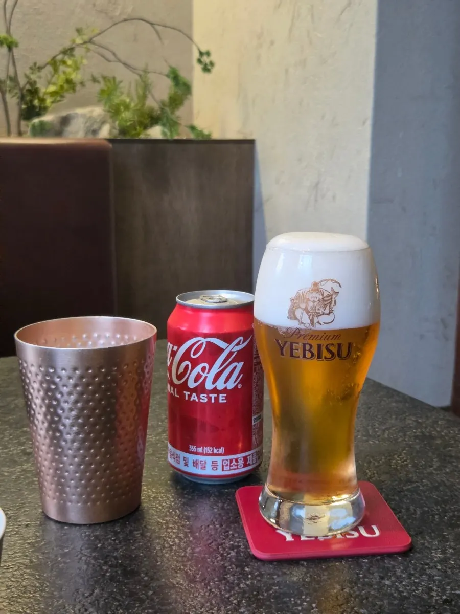 A glass of Yebisu draft beer with a foamy head