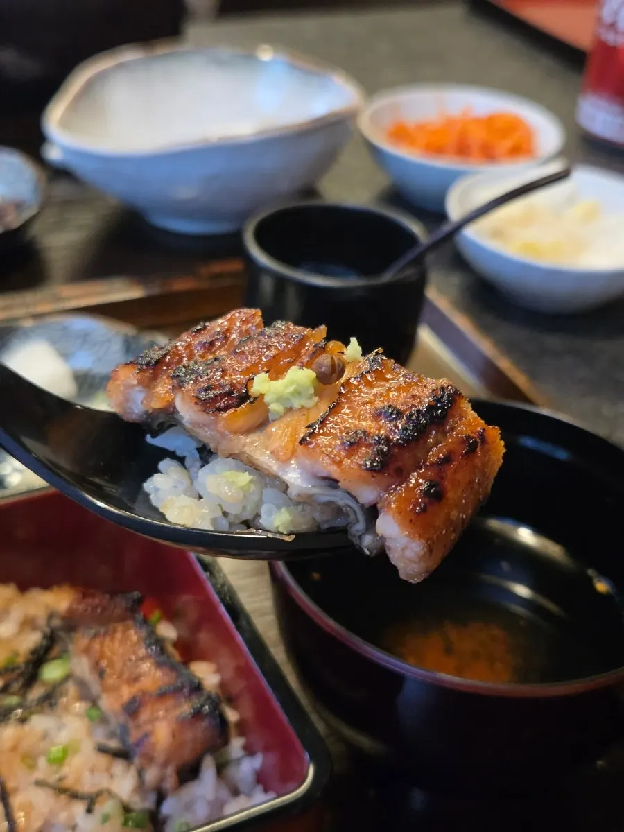 A bite of the rice bowl with eel lifted up
