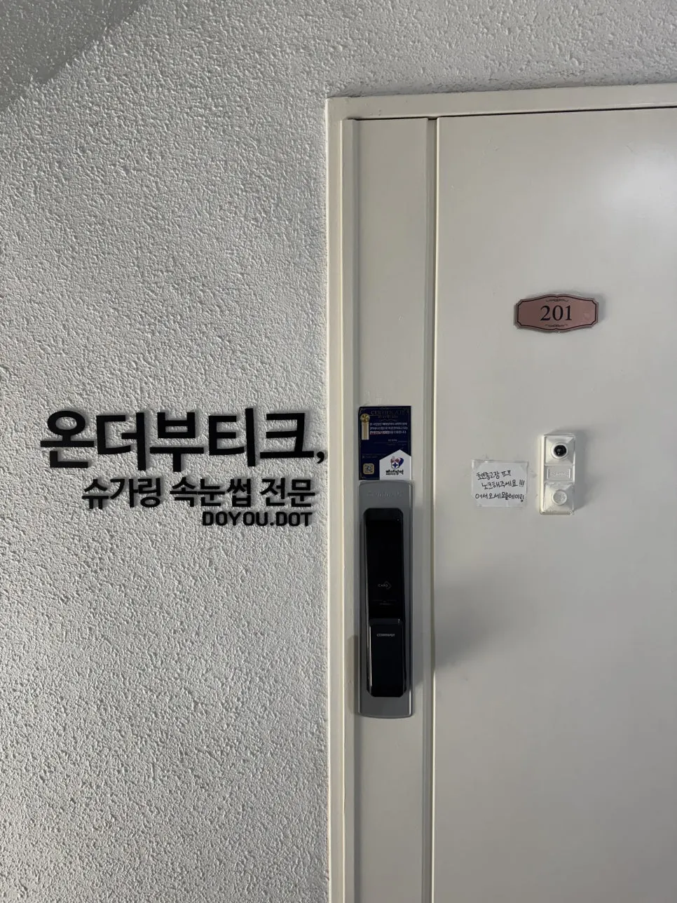 Storefront door of unit 201 with the logo attached