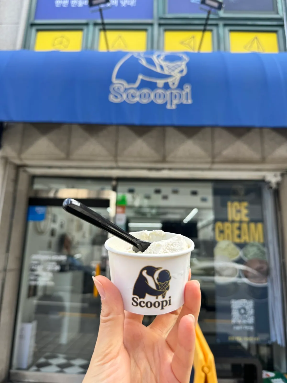 Scoopy's exterior with a blue awning and penguin standee