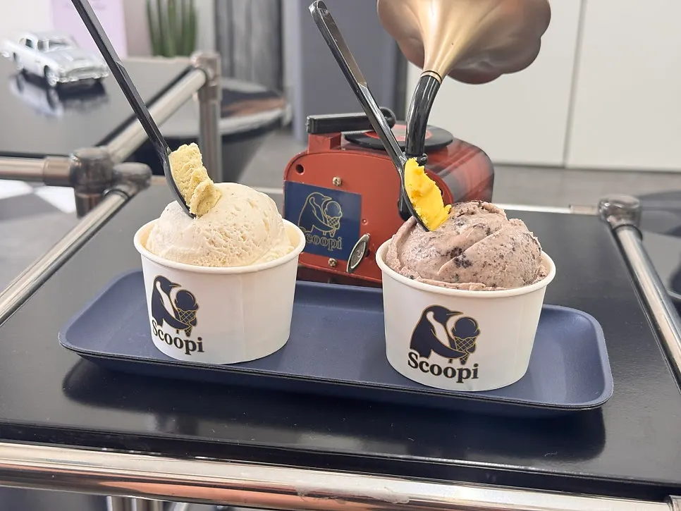 Sign explaining the free taster scoop policy next to the showcase