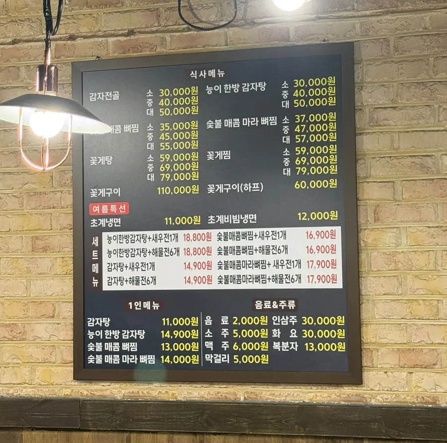 Menu board listing gamja jeongol, ppyeo jjim, and flower crab stew at Haeseonok Seolleung Branch