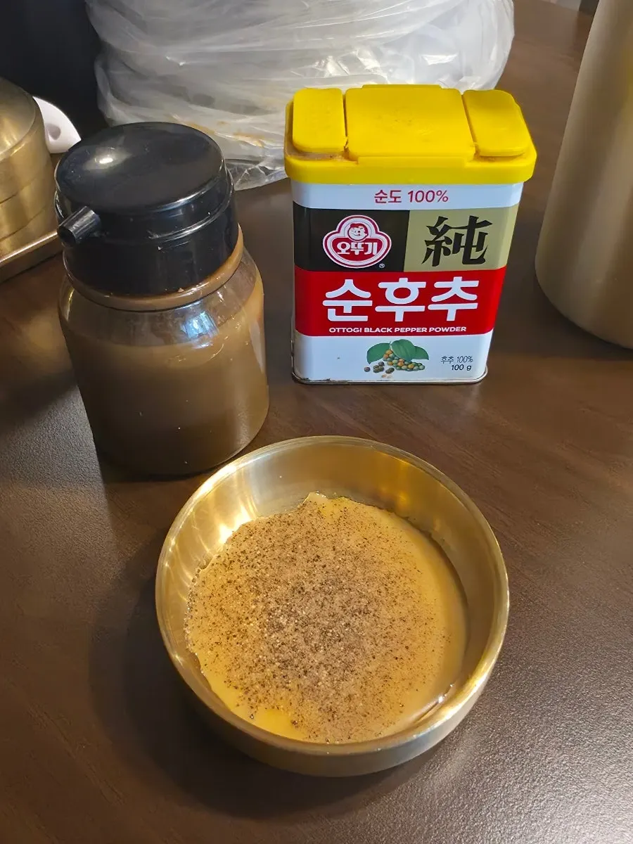 Pepper shaker and seasoning sauce on the table