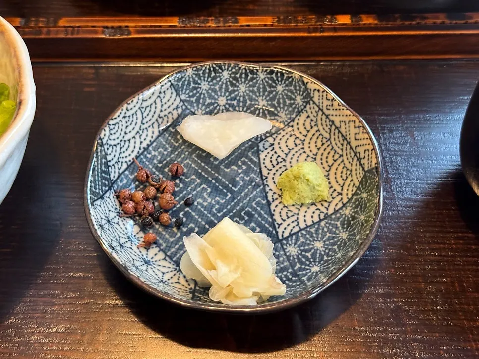 Plate of pickled sansho pepper, wasabi, and pickled ginger accompaniments