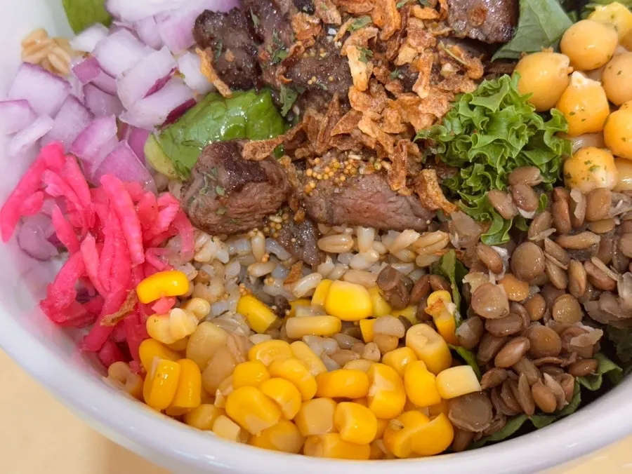 Half-eaten bowl of steak poke