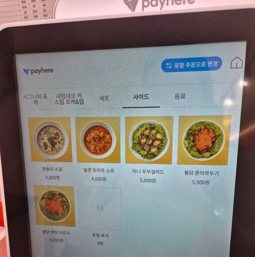 Sign showing Hola Poke's side dish options