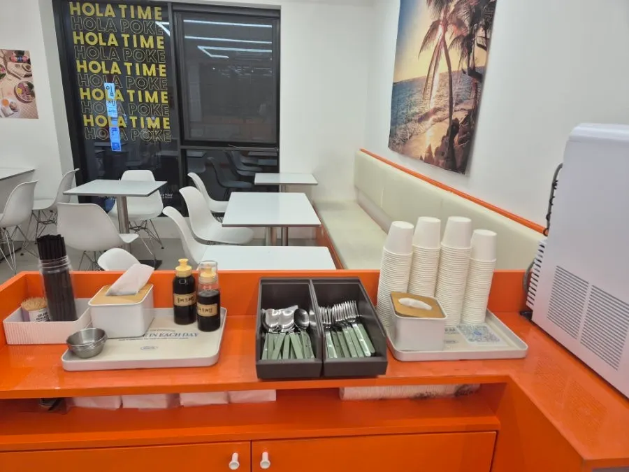 Self-service bar with utensils, sauces, and water