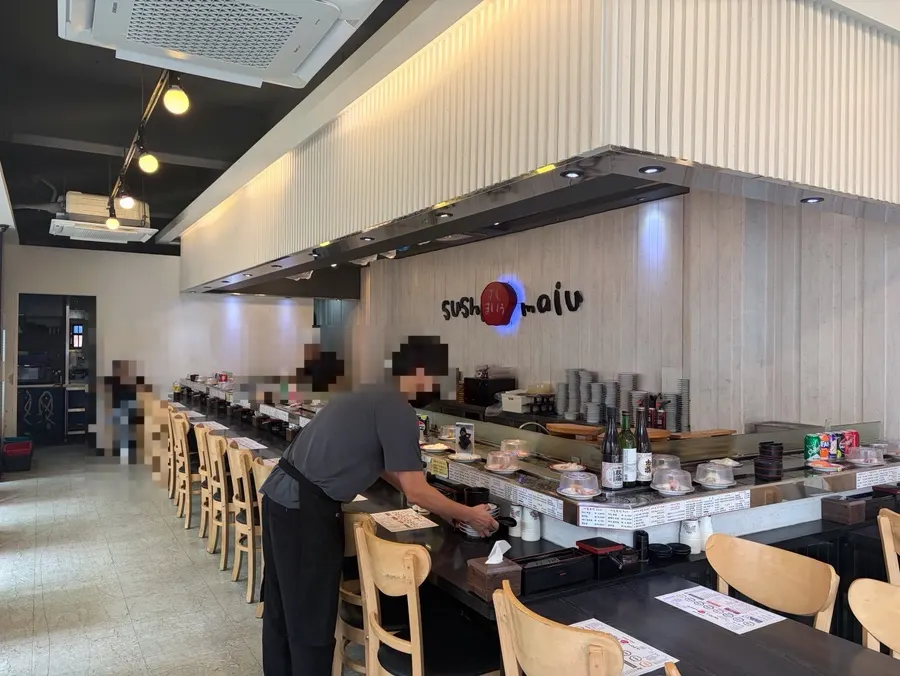 Quiet conveyor-belt sushi seating during a slow lunch hour