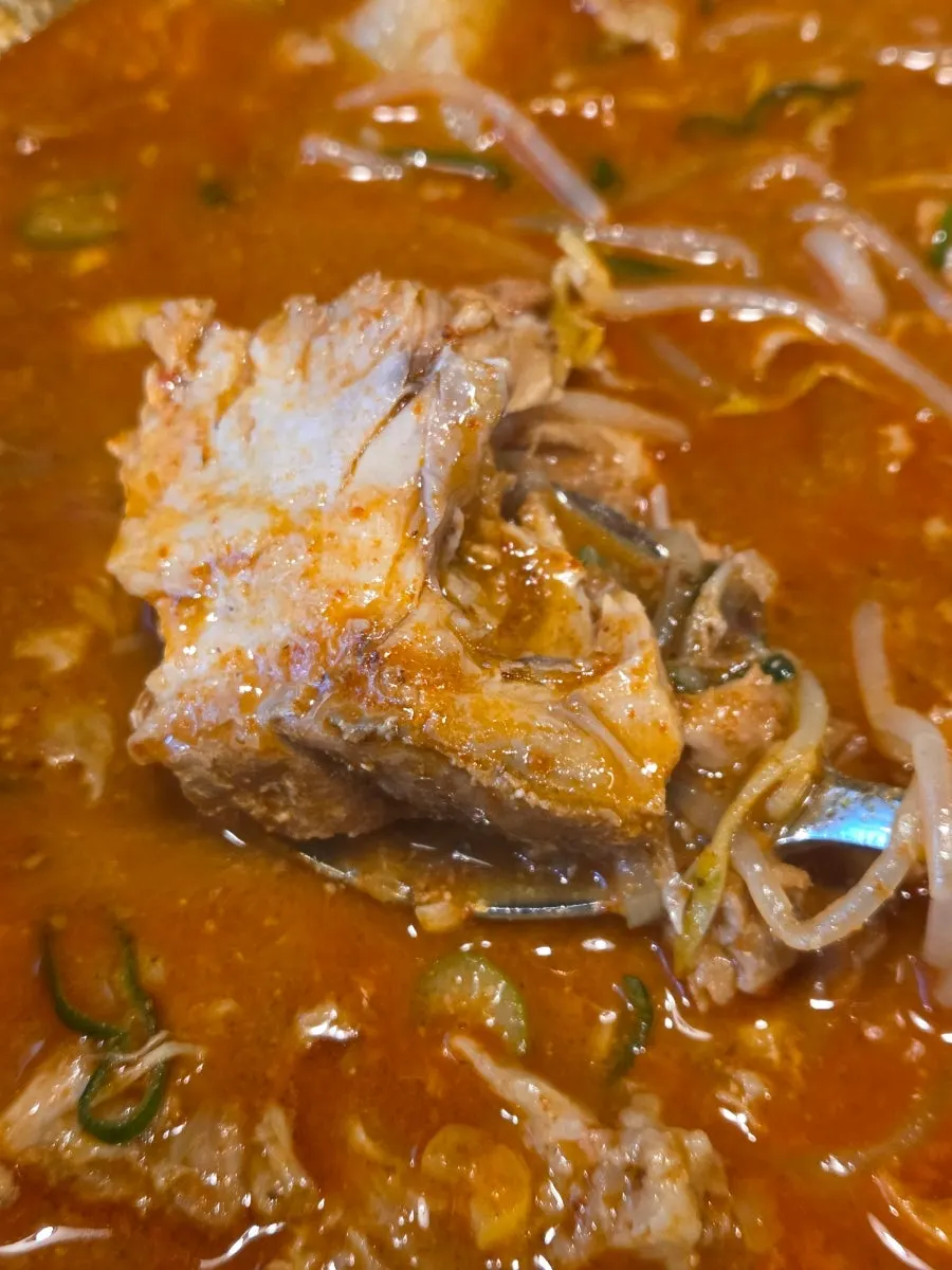 Boneless gamjatang meat scooped up with a spoon