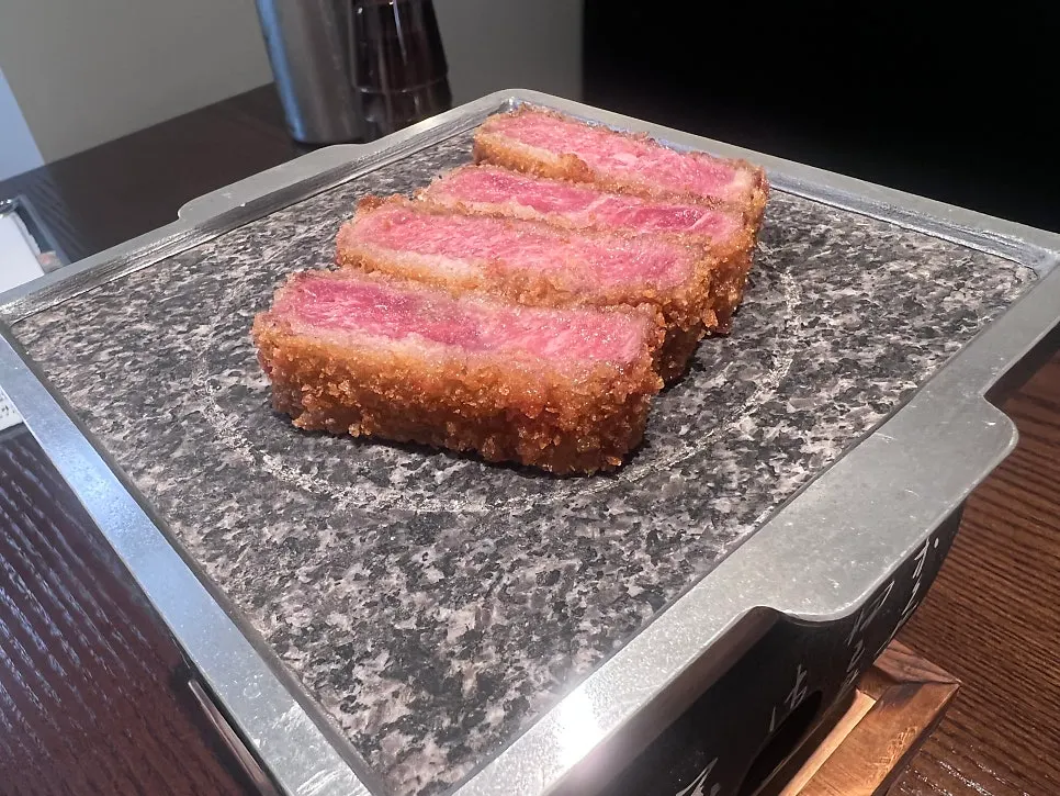 A piece of sirloin gyukatsu cooked on the hot stone