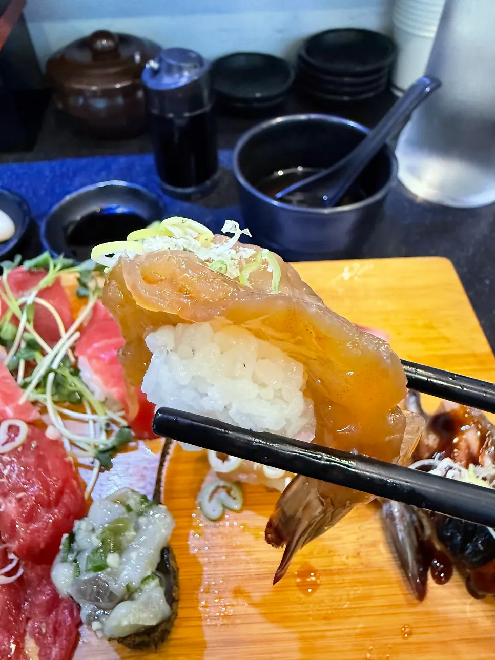 Side view of a large soy-marinated shrimp sushi holding rice
