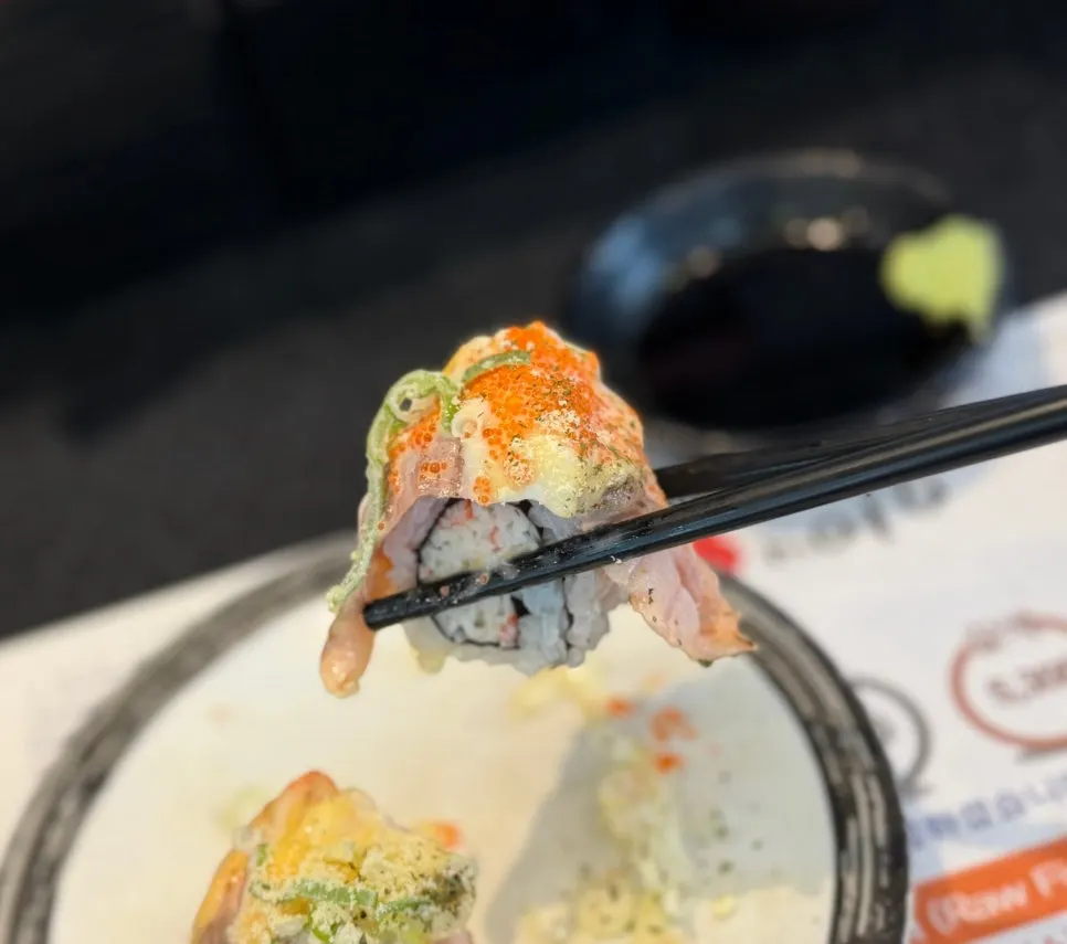Close-up of warm grilled sushi topped with cheese