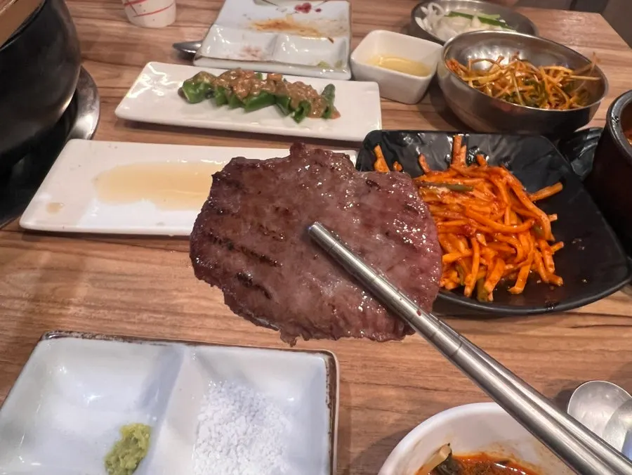 Beef tongue grilling next to lemon sauce