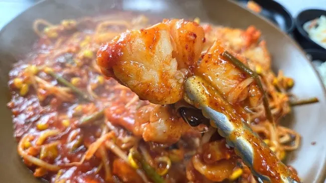 Agujjim topped with bean sprouts and minari