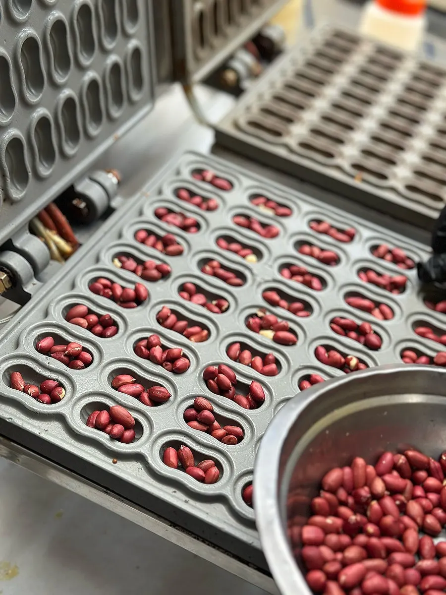 Batter and peanuts being poured into the peanut bread mold