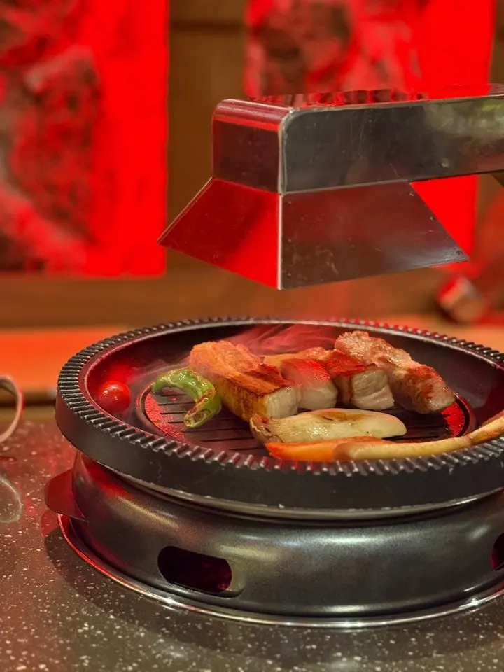 Pork belly turning golden brown over the charcoal brazier