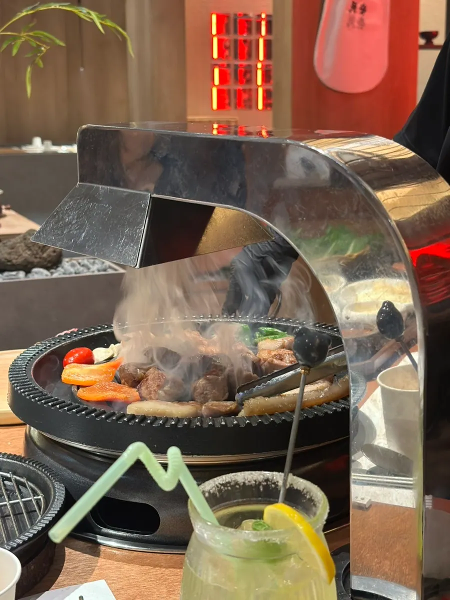 Staff grilling pork belly and pork neck on the brazier