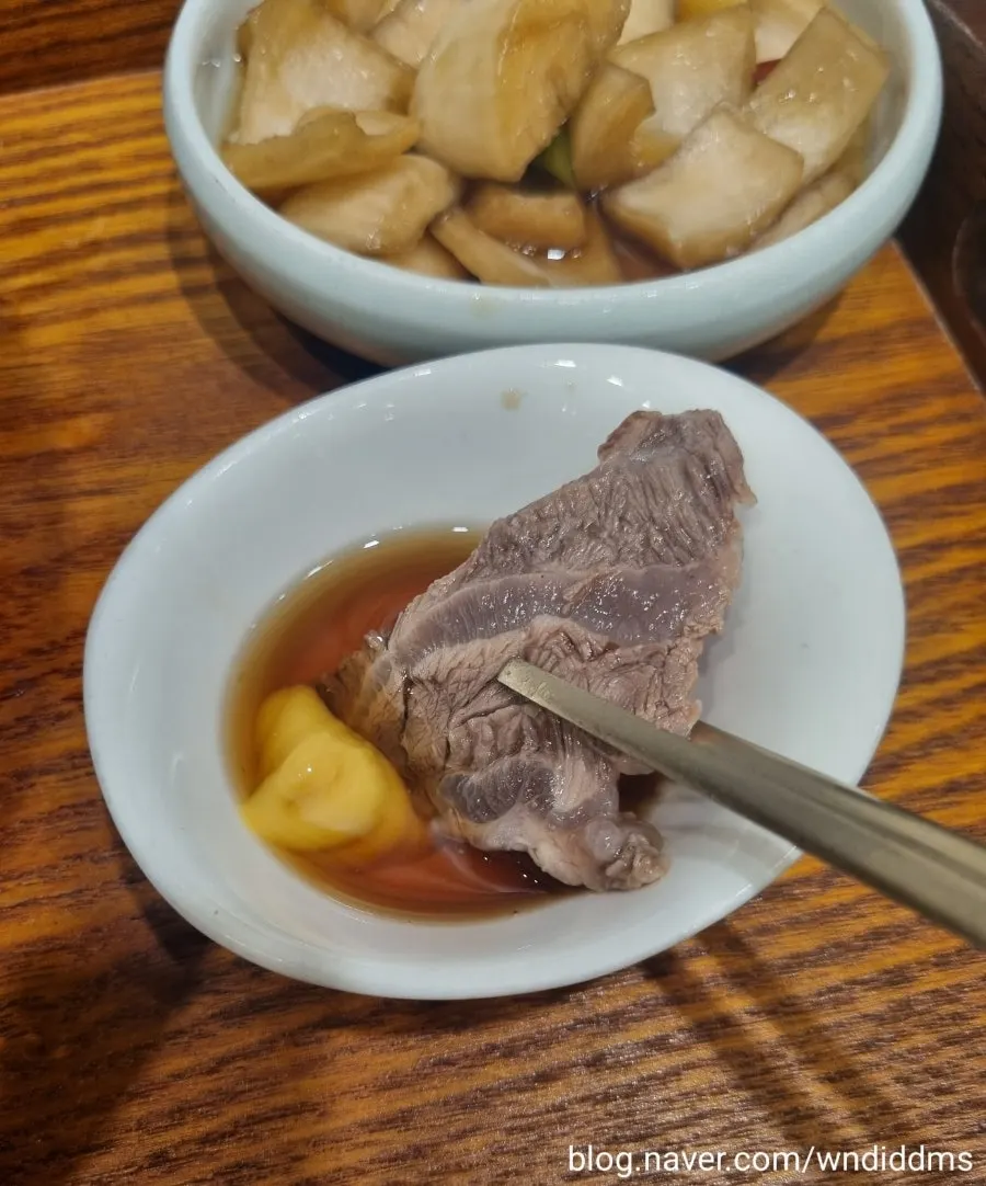 젓가락으로 집어 든 아롱사태 한 점