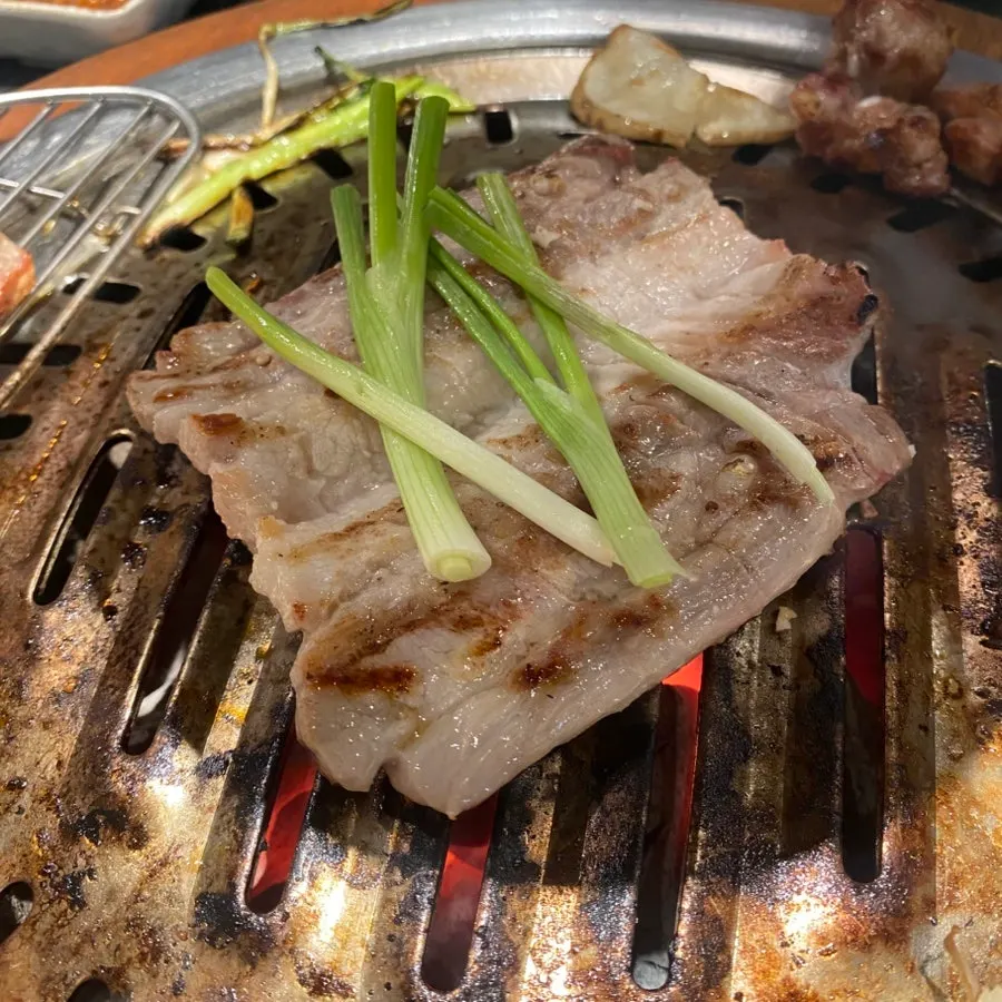 Pork ribs grilling with scallions on top