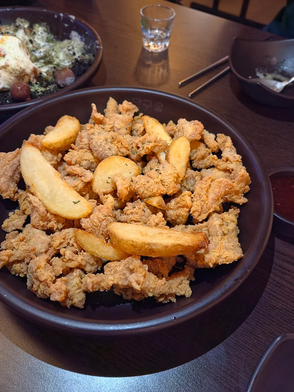 A plate of boneless chicken served with wedge fries