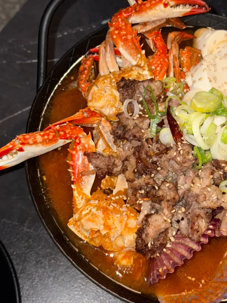Spicy soft tofu beef belly seafood hot pot piled high with seafood and beef belly