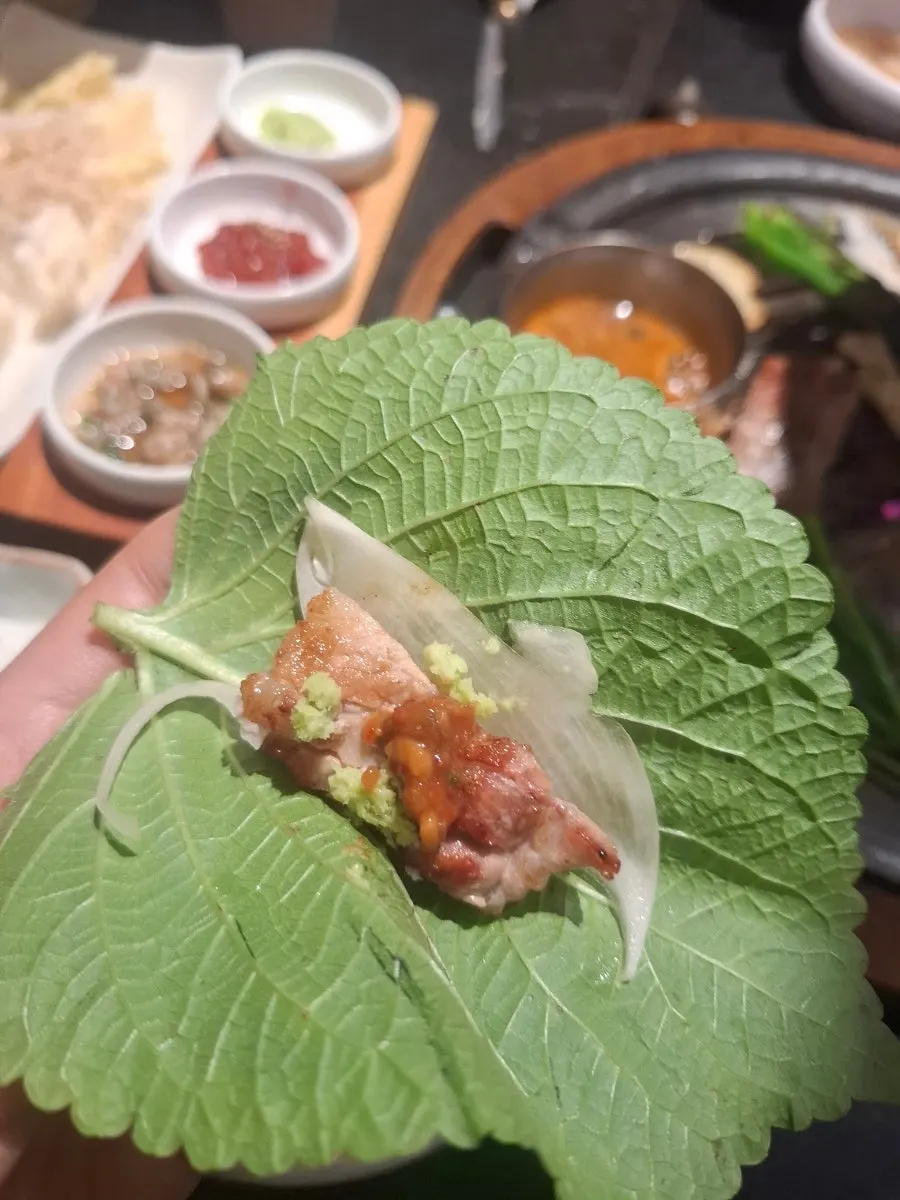 Trozo de costilla de cerdo acompañado de hojas para envolver
