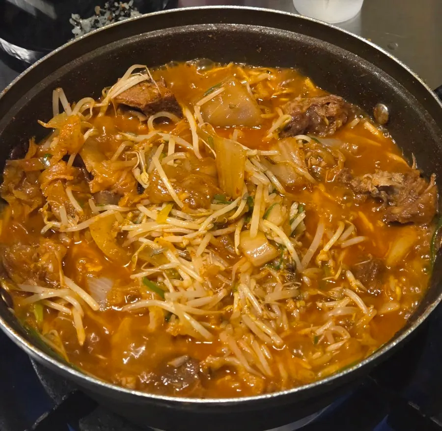Yangpuni braised ribs topped with aged kimchi, bean sprouts, and green onion