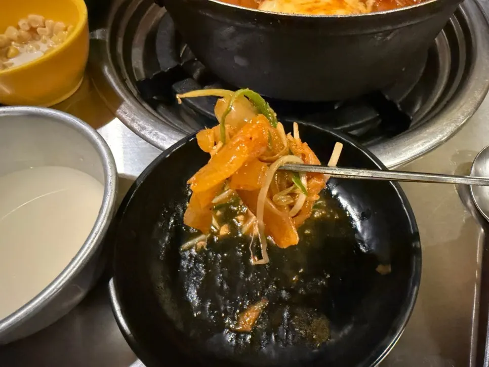 Chopsticks lifting a tender piece of pork rib
