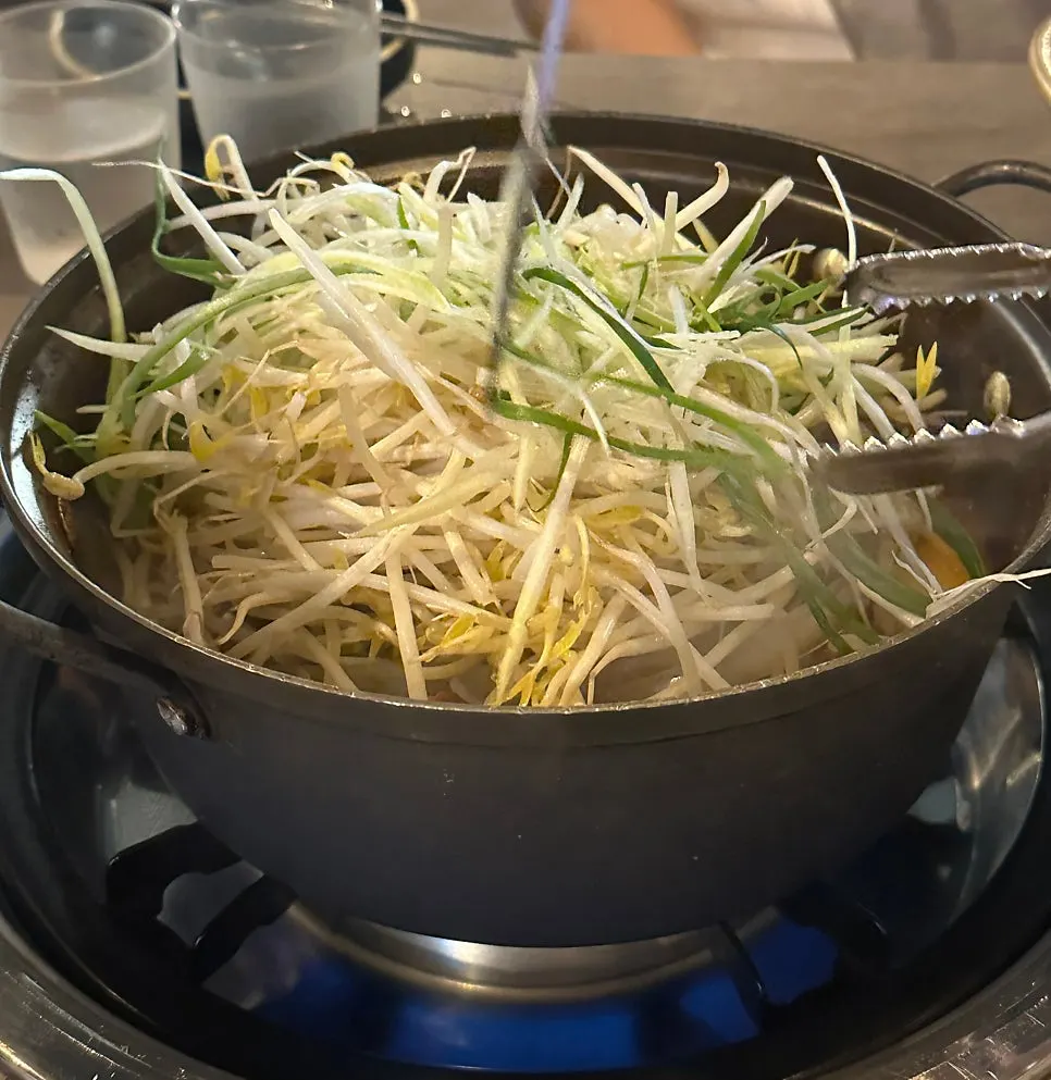 Yangpuni galbijjim topped with bean sprouts and scallion shreds