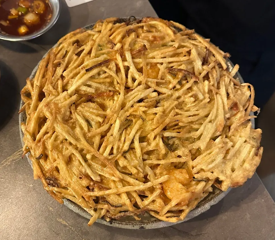 Picking up sauce-coated ribs with bean sprouts