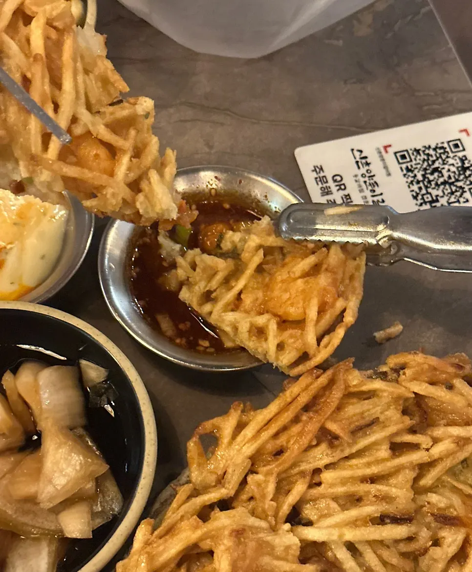 Dipping seafood potato pancake into sauce
