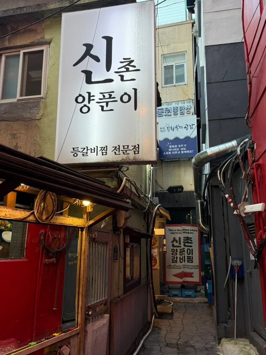 Signage for Sinchon Yangpuni Seomyeon Main Branch in a Seomyeon alley