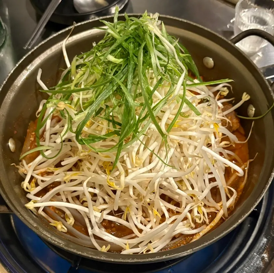 A pot of spicy galbijjim topped with bean sprouts