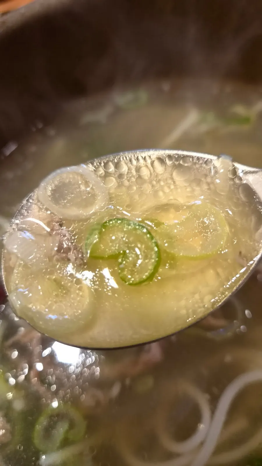 Galbitang with meat and noodles together on the spoon