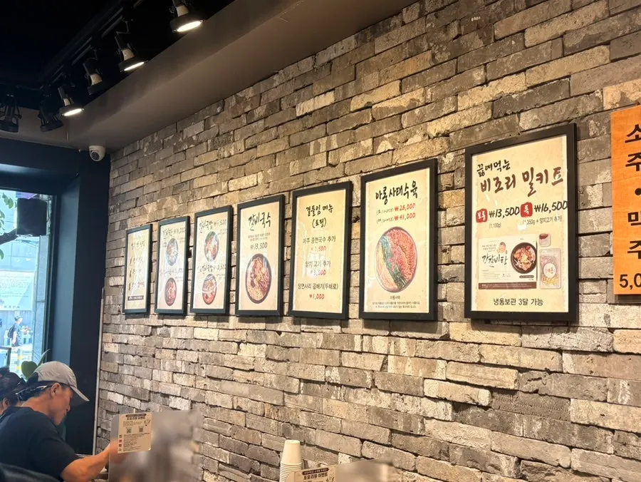 Menu items framed and hung on the wall at Gang Galbitang