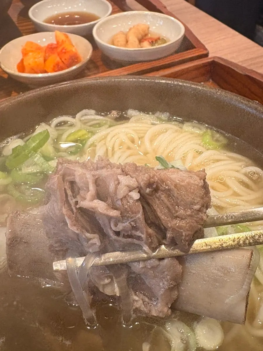 Noodles from the galbitang lifted up with chopsticks
