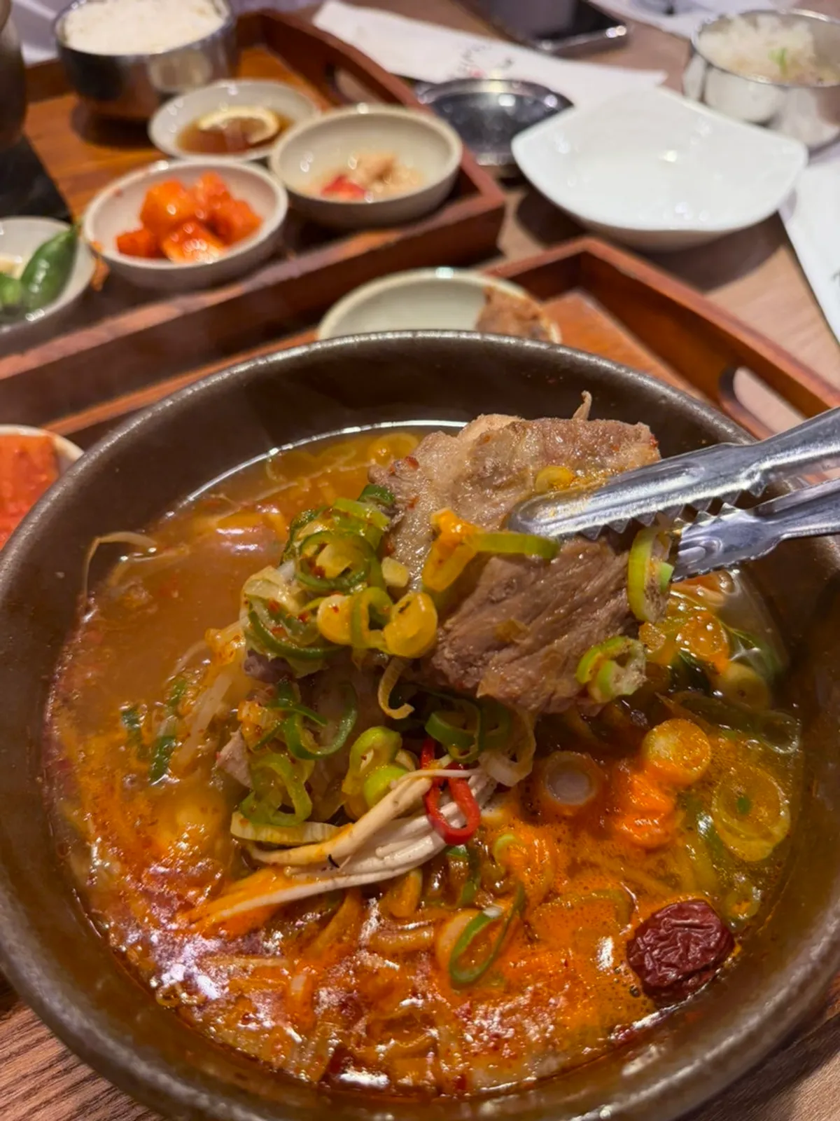 Bowl of spicy galbitang with bean sprouts and radish