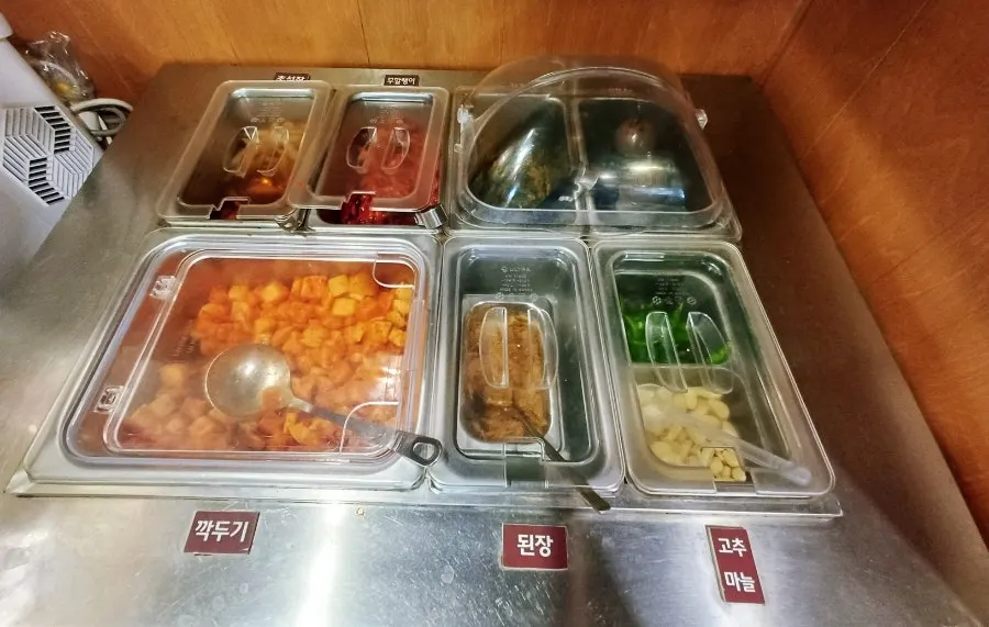 Self-serve corner with kkakdugi and pickled vegetables