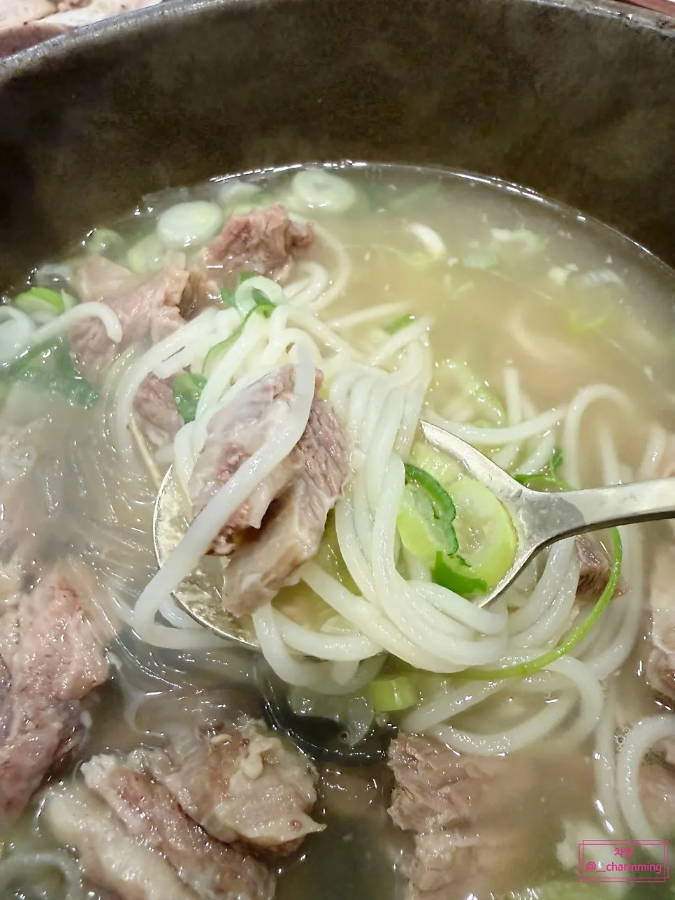 Close-up of galbitang broth and glass noodles