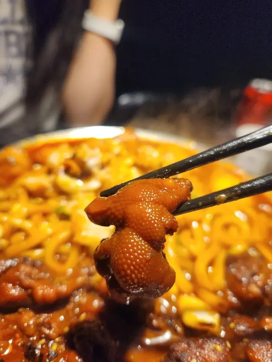 Chopsticks picking up beef intestines from the O-Dae-Bal platter