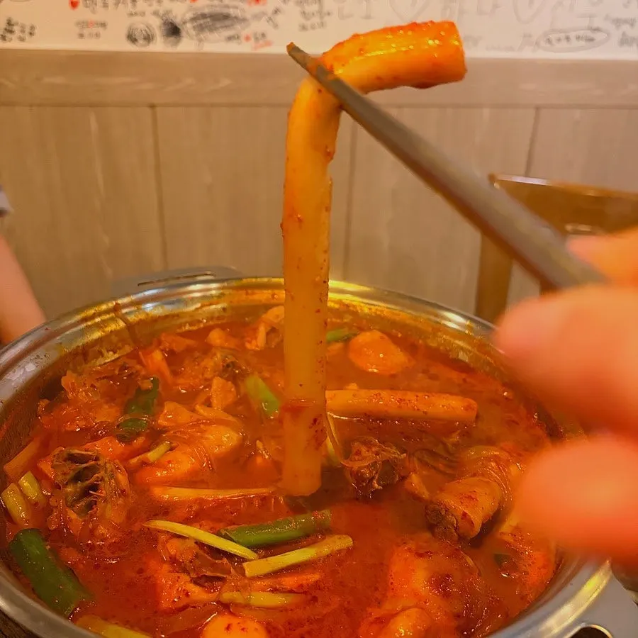 양념에 비빈 밥에 닭고기를 얹은 한 숟갈