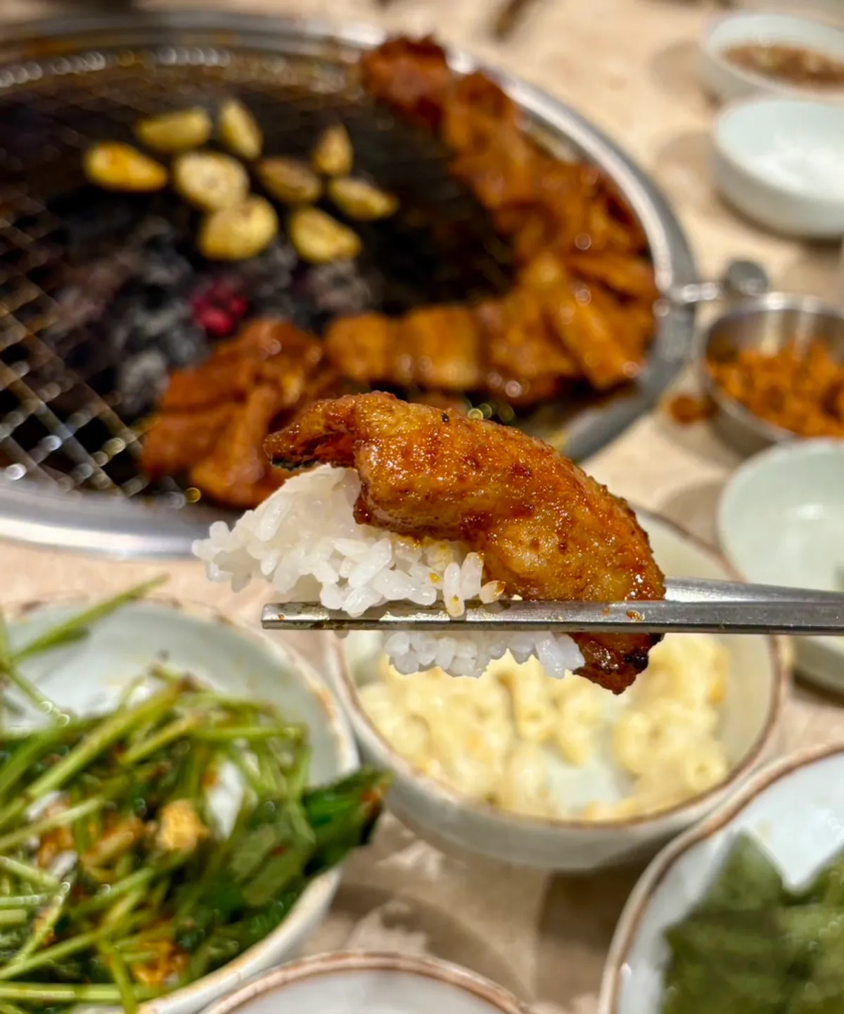 A piece of gochujang samgyeopsal placed on white rice