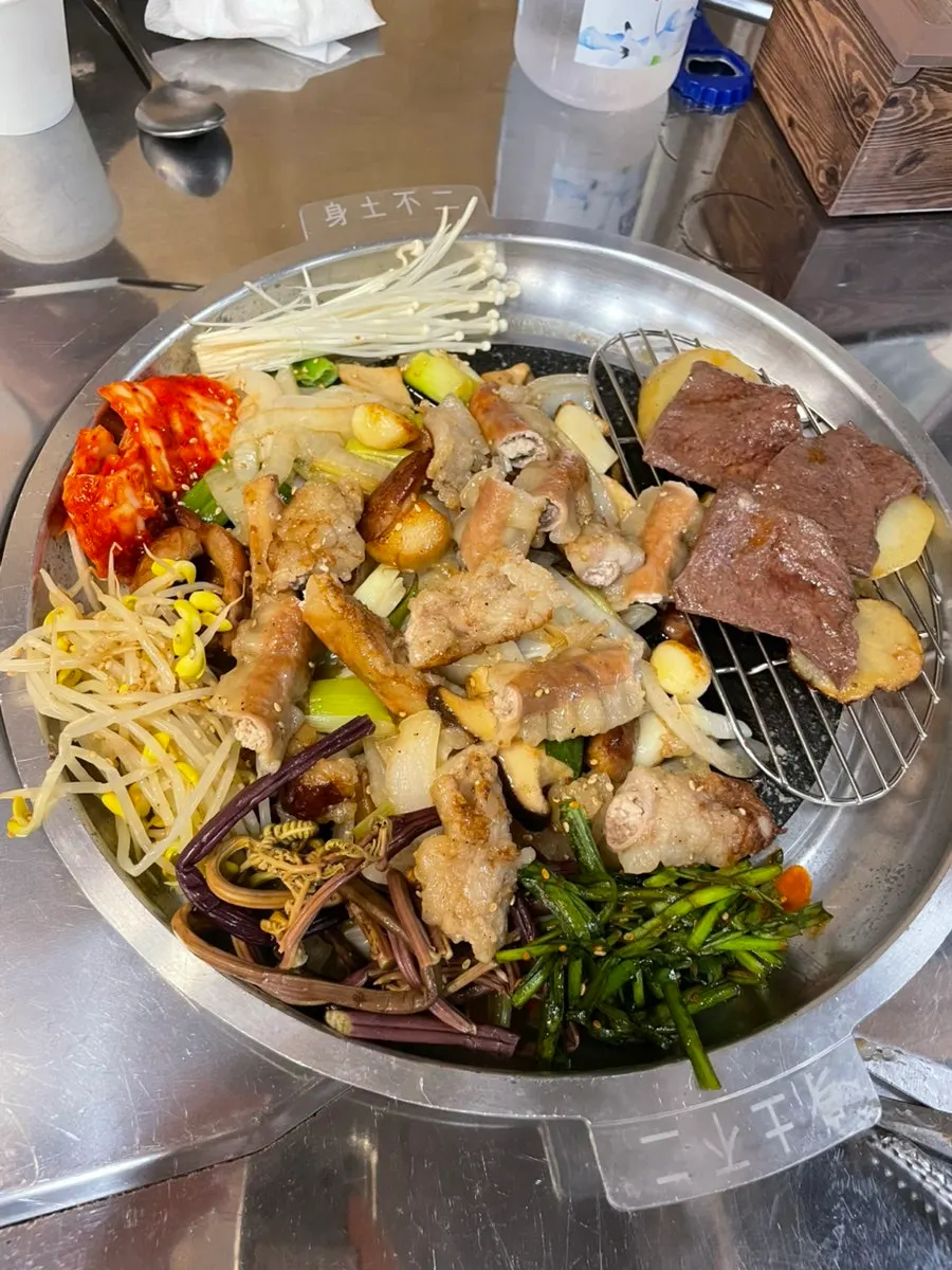 Gopchang cooking on the grill with vegetables