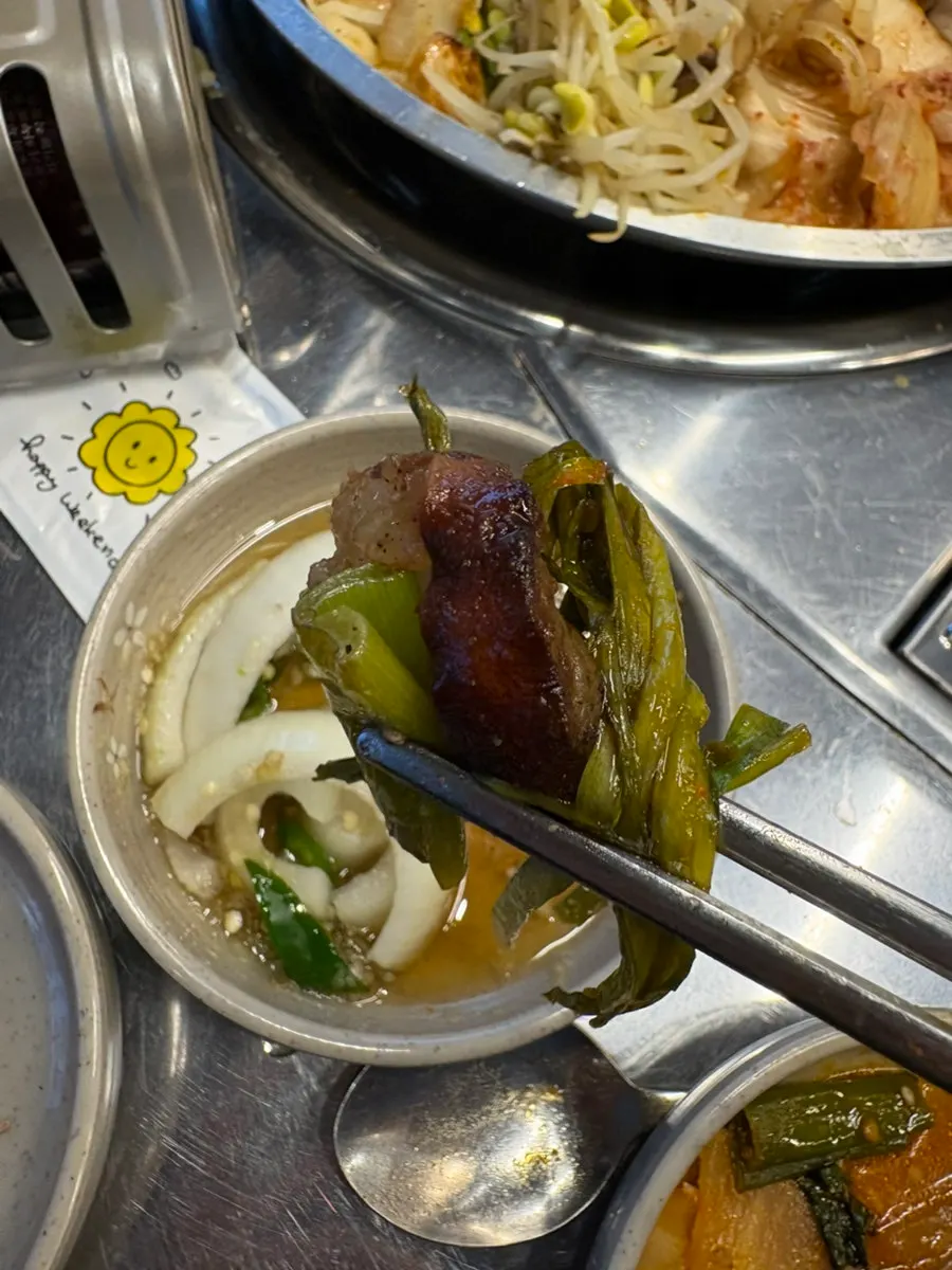 A piece of gopchang dipped in sauce