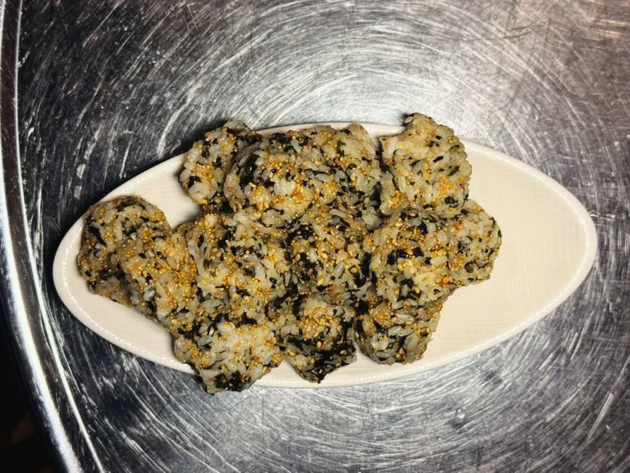 Furikake rice ball being mixed and shaped with gloves