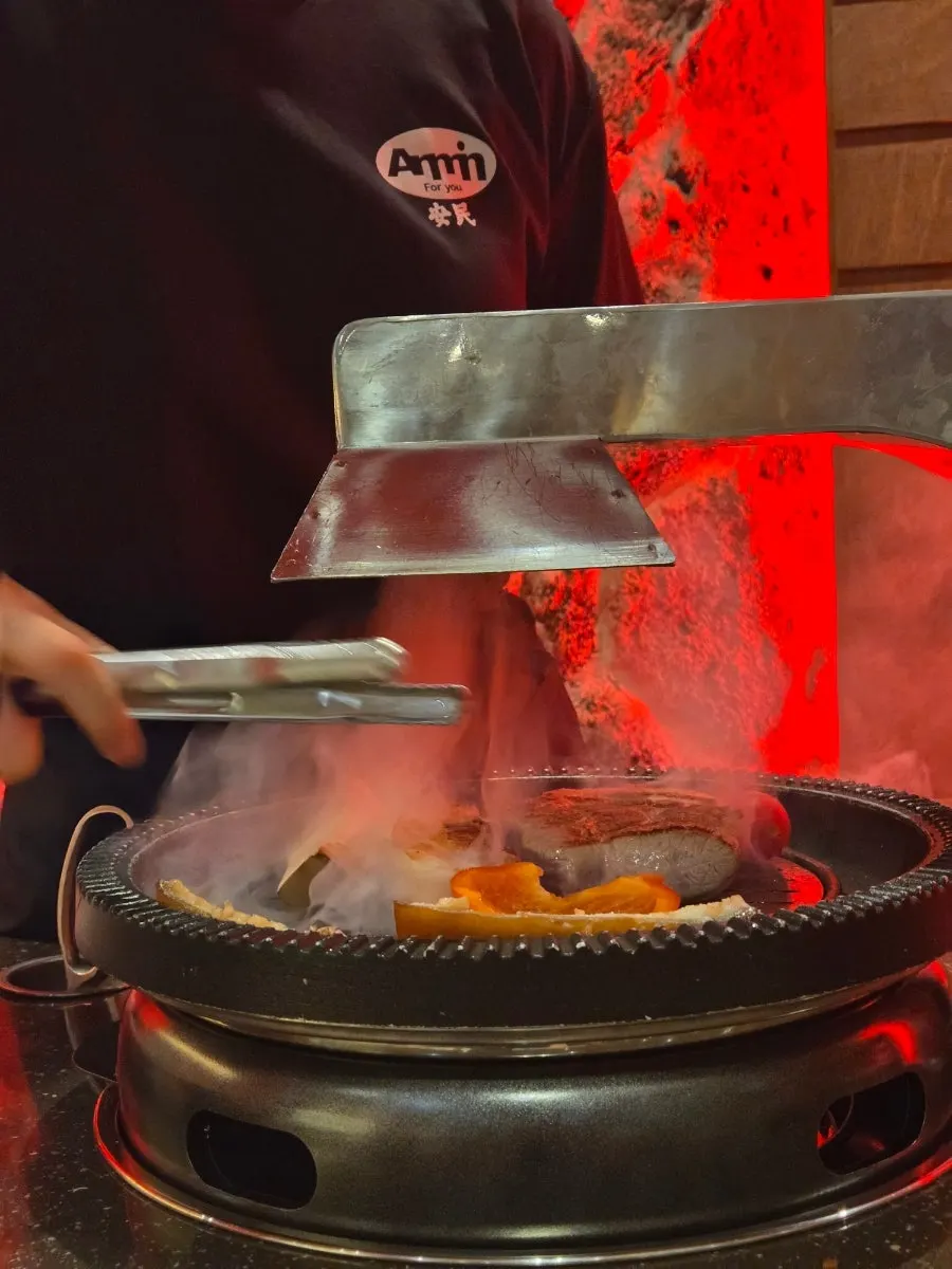 Staff grilling thick cuts of pork